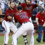 Arizona Diamondbacks' Daniel Descalso (3) celebrates his walkoff two-run home run against the Colorado Rockies with Chris Owings, left, and Archie Bradley (25) during the 13th inning of a baseball game Sunday, April 30, 2017, in Phoenix. (AP Photo/Ross D. Franklin)