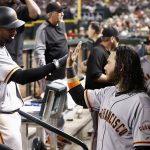 San Francisco Giants' Eduardo Nunez, left, gets a high-five from Brandon Crawford, right, after Nunez scored a run against the Arizona Diamondbacks during the fifth inning of a baseball game Tuesday, April 4, 2017, in Phoenix. (AP Photo/Ross D. Franklin)