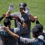 Arizona Diamondbacks' Chris Iannetta, top, is congratulated by David Peralta, left, Jerry Narron, second from right, and manager Torey Lovullo after hitting a solo home run during the second inning of a baseball game against the Los Angeles Dodgers, Sunday, April 16, 2017, in Los Angeles. (AP Photo/Mark J. Terrill)