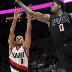 Phoenix Suns forward Marquese Chriss, right, grabs a rebound away from Portland Trail Blazers guard CJ McCollum during the second half of an NBA basketball game in Portland, Ore., Saturday, April 1, 2017. The Blazers won 130-117. (AP Photo/Steve Dykes)