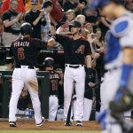 Arizona Diamondbacks' David Peralta (6) is congratulated by teammate Jeremy Hazelbaker, center, after scoring against the Los Angeles Dodgers on a single by the Diamondbacks' Paul Goldschmidt during the eighth inning of a baseball game, Saturday, April 22, 2017, in Phoenix. Peralta had a franchise record four doubles in the Diamondbacks 11-5 victory over the Dodgers. (AP Photo/Ralph Freso)