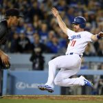 Los Angeles Dodgers second baseman Logan Forsythe, right, scores on a sacrifice fly by Yasiel Puig as Arizona Diamondbacks starting pitcher Zack Greinke takes the off-line throw during the fifth inning of a baseball game, Friday, April 14, 2017, in Los Angeles. (AP Photo/Mark J. Terrill)
