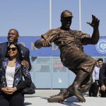 Los Angeles Dodgers co-owner Magic Johnson, left, and wife, Cookie, pose with a bronze statue of Jackie Robinson outside Dodger Stadium before the team's baseball game against the Arizona Diamondbacks, Saturday, April 15, 2017, in Los Angeles. (AP Photo/Jae C. Hong)