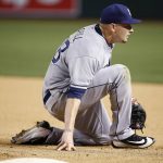 San Diego Padres' Trevor Cahill kneels on the ground after losing control of a ball thrown to him at first base on a hit by Arizona Diamondbacks' Brandon Drury during the fifth inning of a baseball game, Wednesday, April 26, 2017, in Phoenix. (AP Photo/Ross D. Franklin)
