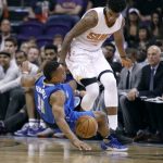 Dallas Mavericks guard Yogi Ferrell (11) falls to the court after colliding with Phoenix Suns forward Marquese Chriss during the first half of an NBA basketball game, Sunday, April 9, 2017, in Phoenix. (AP Photo/Ralph Freso)