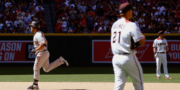San Francisco Giants' Madison Bumgarner, left, rounds the bases after hitting a home run against Ar...