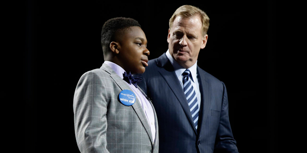 T.J. Owuanibe, 14, left, walks with NFL commissioner Roger Goodell to announce the Baltimore Ravens...