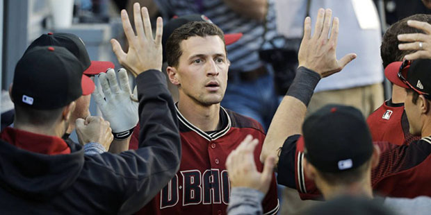 Arizona Diamondbacks' Nick Ahmed, center, is congratulated by teammates in the dugout after hitting...