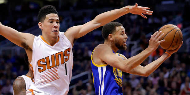 Golden State Warriors guard Stephen Curry drives past Phoenix Suns guard Devin Booker (1) during th...