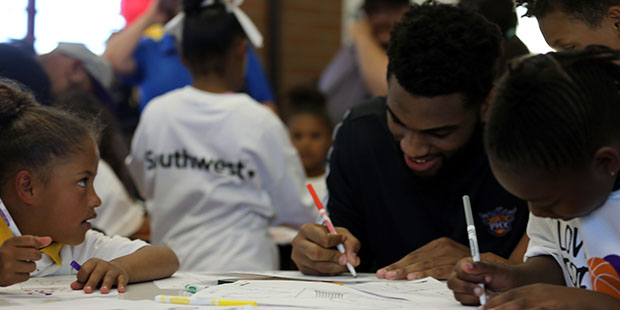 Suns forward Alan Williams drawing with kids at the newly renovated learning room of the Eastlake C...