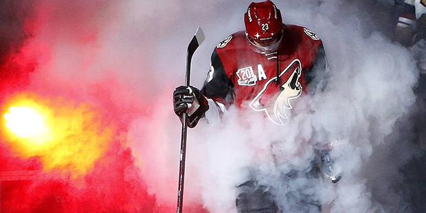 Arizona Coyotes' Oliver Ekman-Larsson emerges from the smoke during player introductions prior to a...