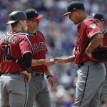 Arizona Diamondbacks manager Torey Lovullo, second from left, takes the ball from staring pitcher Taijuan Walker, third from left, as catcher Chris Herrmann, left, and third baseman Jake Lamb look on as Walker is pulled from the mound after giving up an RBI-double to Colorado Rockies' Trevor Story in the sixth inning of a baseball game, Sunday, May 7, 2017, in Denver. (AP Photo/David Zalubowski)