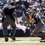 Arizona Diamondbacks catcher Chris Iannetta, right, spins after he tags out San Diego Padres' Erick Aybar, trying to score on a bunt by Manuel Margot, as home plate umpire Ramon De Jesus, left, watches during the fifth inning of a baseball game in San Diego, Sunday, May 21, 2017. (AP Photo/Alex Gallardo)