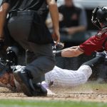 Colorado Rockies' Mark Reynolds, left, slides safely into home plate to score on a double by Trevor Story as Arizona Diamondbacks catcher Chris Herrmann applies a late tag in the sixth inning of a baseball game, Sunday, May 7, 2017, in Denver. (AP Photo/David Zalubowski)