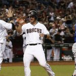 Arizona Diamondbacks' Jeff Mathis (2) and Daniel Descalso (3) celebrate as both score runs as New York Mets' Rene Rivera, right, watches for the baseball in the infield during the third inning of a baseball game, Tuesday, May 16, 2017, in Phoenix. (AP Photo/Ross D. Franklin)