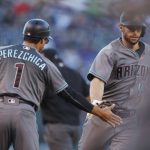 Arizona Diamondbacks third base coach Tony Perezchica, left, congratulates Paul Goldschmidt who circles the bases after hitting a solo home run off Colorado Rockies relief pitcher German Marquez in the first inning of a baseball game Friday, May 5, 2017, in Denver. (AP Photo/David Zalubowski)