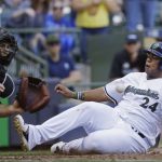 Milwaukee Brewers' Jesus Aguilar, right, scores ahead of the tag by Arizona Diamondbacks' Chris Ianetta, left, during the sixth inning of a baseball game Sunday, May 28, 2017, in Milwaukee. (AP Photo/Jeffrey Phelps)