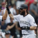 Colorado Rockies' DJ LeMahieu, left, congratulates Charlie Blackmon as he returns to the dugout after hitting a solo home run off Arizona Diamondbacks relief pitcher J.J. Hoover in the seventh inning of a baseball game, Sunday, May 7, 2017, in Denver. (AP Photo/David Zalubowski)