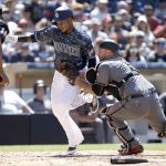 Arizona Diamondbacks catcher Chris Iannetta, right, tags out San Diego Padres' Erick Aybar, trying to score on a bunt by Manuel Margot, as home plate umpire Ramon De Jesus, left, watches during the fifth inning of a baseball game in San Diego, Sunday, May 21, 2017. (AP Photo/Alex Gallardo)
