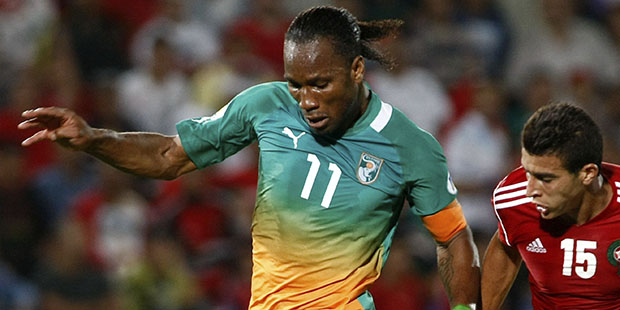 FILE - In this June 9, 2012, file photo, Ivory Coast's Didier Drogba, left, challenges for the ball...