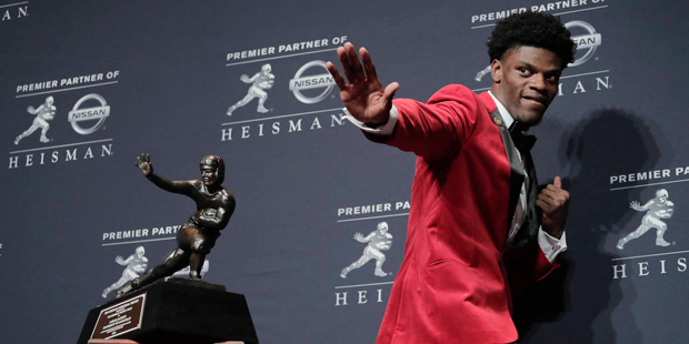 Louisville's Lamar Jackson poses with the Heisman Trophy after winning the award, in New York. Edit...