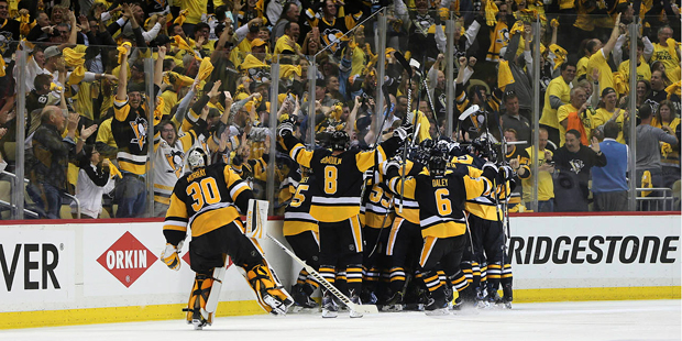 Pittsburgh Penguins players and fans celebrate as the Penguins' Chris Kunitz scores a game winning ...