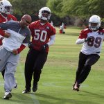 Coach Larry Foote is chased down by Kareem Martin, Gabe Martin and Hakeem Valles during an OTA practice June 1. (Photo by Adam Green/Arizona Sports)