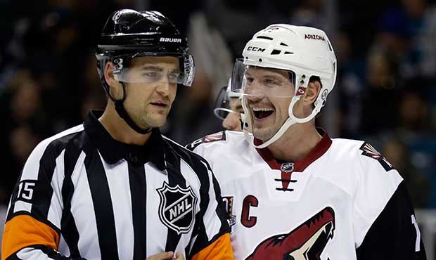 Arizona Coyotes' Shane Doan, right, smile with a referee during the first period of an NHL hockey g...