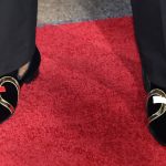 Kentucky's De'Aaron Fox shows off his shoes as he stops for photos while walking the red carpet before the start of the NBA basketball draft, Thursday, June 22, 2017, in New York. (AP Photo/Frank Franklin II)