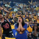 Fans watch television coverage of Game 4 of basketball's NBA Finals between the Golden State Warriors and the Cleveland Cavaliers, Friday, June 9, 2017, at Oracle Arena in Oakland, Calif. (AP Photo/Marcio Jose Sanchez)
