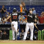 Miami Marlins' Giancarlo Stanton (27) is congratulated by Justin Bour after Stanton scored on a single by Marcell Ozuna during the eighth inning of a baseball game against the Arizona Diamondbacks, Saturday, June 3, 2017, in Miami. The Marlins won 3-0. (AP Photo/Wilfredo Lee)