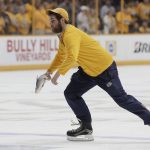 A worker removes a catfish thrown onto the ice after a Nashville Predators goal against the Pittsburgh Penguins during the third period in Game 3 of the NHL hockey Stanley Cup Finals Saturday, June 3, 2017, in Nashville, Tenn. (AP Photo/Mark Humphrey)