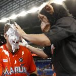 Wearing a chimpanzee mask, Miami Marlins' Miguel Rojas, right, hits A.J. Ellis with a cream pie after they defeated the Arizona Diamondbacks in a baseball game, Sunday, June 4, 2017, in Miami. (AP Photo/Wilfredo Lee)