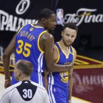 Golden State Warriors forward Kevin Durant (35) holds back Stephen Curry (30) from referee John Goble (30) during the first half against the Cleveland Cavaliers in Game 4 of basketball's NBA Finals in Cleveland, Friday, June 9, 2017. (AP Photo/Ron Schwane)