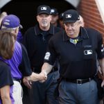 Crew chief Joe West, right, is congratulated as he heads to the field to umpire his 5,000th career game as the Colorado Rockies host the Arizona Diamondbacks in the first inning of a baseball game Tuesday, June 20, 2017, in Denver. (AP Photo/David Zalubowski)