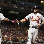St. Louis Cardinals' Matt Carpenter (13) celebrates with Yadier Molina (4) after Carpenter scored a run against the Arizona Diamondbacks during the first inning of a baseball game, Tuesday, June 27, 2017, in Phoenix. (AP Photo/Ross D. Franklin)