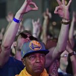 Golden State Warriors fan Charles Chapman Jr., front, stands while Cleveland Cavaliers fans celebrate during a watch party outside Quicken Loans Arena for Game 4 of the basketball's NBA Finals between the Cavaliers and the Golden State Warriors, Friday, June 9, 2017, in Cleveland. (AP Photo/David Dermer)