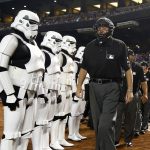 Umpire Gary Cederstrom, right, leads other umpires out onto the field as they walk past stormtroopers on "Star Wars Night" prior to a baseball game between the Arizona Diamondbacks and the Philadelphia Phillies, Saturday, June 24, 2017, in Phoenix. (AP Photo/Ross D. Franklin)