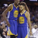 Golden State Warriors' Kevin Durant (35) hugs Stephen Curry (30) during the first half against the Cleveland Cavaliers in Game 4 of basketball's NBA Finals in Cleveland, Friday, June 9, 2017. (AP Photo/Tony Dejak)