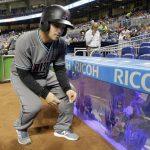 A ball boy removes safety glass from an aquarium behind home plate which broke during the first inning of a baseball game between the Miami Marlins and the Arizona Diamondbacks, Friday, June 2, 2017, in Miami. (AP Photo/Lynne Sladky)