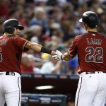 Arizona Diamondbacks' David Peralta (6) celebrates his run scored against the Milwaukee Brewers with Jake Lamb (22) during the first inning of a baseball game, Sunday, June 11, 2017, in Phoenix. (AP Photo/Ross D. Franklin)