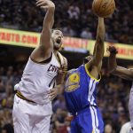Cleveland Cavaliers forward Kevin Love (0) and Golden State Warriors forward Andre Iguodala (9) reach for the ball during the first half of Game 4 of basketball's NBA Finals in Cleveland, Friday, June 9, 2017. (AP Photo/Tony Dejak)
