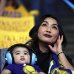 Melissa Lucero, right, and her 8-month-old son Carter Pacoma watch television coverage of Game 4 of basketball's NBA Finals between the Golden State Warriors and the Cleveland Cavaliers, Friday, June 9, 2017, at Oracle Arena in Oakland, Calif. (AP Photo/Marcio Jose Sanchez)
