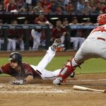 Arizona Diamondbacks' Nick Ahmed, left, scores a run as Philadelphia Phillies' Andrew Knapp, right, makes a catch on a late throw to home plate during the fourth inning of a baseball game Sunday, June 25, 2017, in Phoenix. (AP Photo/Ross D. Franklin)