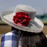 A horse racing fan waits along the fence before the start of the sixth race before the 149th running of the Belmont Stakes horse race, Saturday, June 10, 2017, in Elmont, N.Y. (AP Photo/Julie Jacobson)