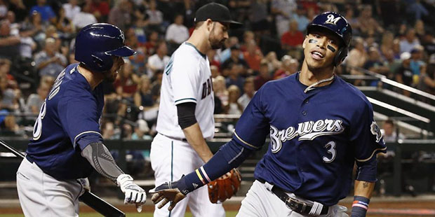 Milwaukee Brewers' Orlando Arcia (3) slaps hands with Eric Sogard, left, after Arcia scored a run, ...