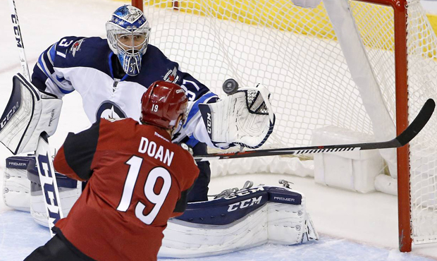 Winnipeg Jets goalie Connor Hellebuyck (37) reaches out to make a save on a shot as Arizona Coyotes...