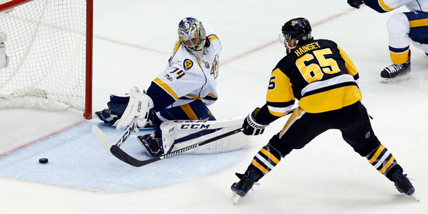 Pittsburgh Penguins' Ron Hainsey (65) pokes the puck past Nashville Predators goalie Juuse Saros (7...