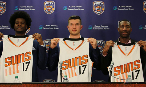 Josh Jackson (left), Alec Peters (center) and Davon Reed (right) hold up Suns jerseys with the numb...