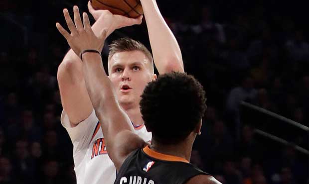 New York Knicks' Kristaps Porzingis (6), of Latvia, shoots over Phoenix Suns' Marquese Chriss (0) d...